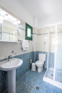 a bathroom with a sink and a toilet and a shower at Dilina Studios in Arkasa