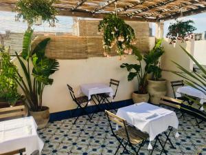 um restaurante com mesas e cadeiras e vasos de plantas em Incanto Siciliano em Noto