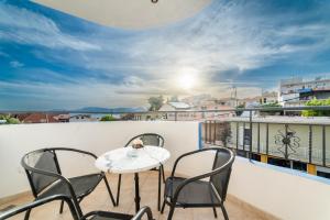 a balcony with three chairs and a table on a roof at Azzurro in Paleros