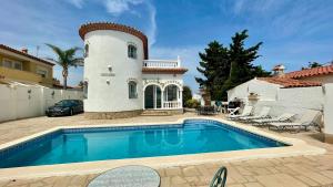 a villa with a swimming pool in front of a house at MEDDAYS VILLA NOAH in Miami Platja