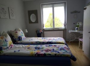 a bedroom with a bed with a quilt on it at AU LOGIS DU SIMSERHOF in Hottviller