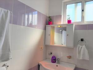 een badkamer met een wastafel, een toilet en een spiegel bij Sazani's Place in Fier