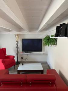 un soggiorno con mobili rossi e TV a schermo piatto di SUITE76 a Torre Santa Susanna