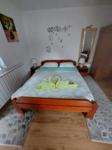 a bed with two pairs of gloves on it at Apartments & Rooms Ramljak in Korenica
