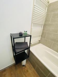 a bathroom with a black shelf next to a bath tub at Alte Scheune in Werneck