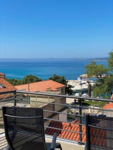 a chair on a balcony with a view of the ocean at Villa Luciana - Old town centre in Baška Voda