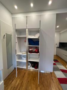 a walk in closet with white cabinets and wood floors at NeStop FVG in Tarvisio