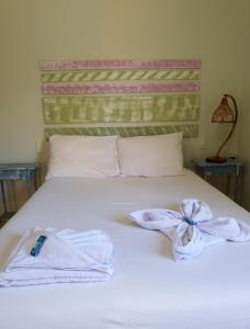 Una cama blanca con toallas encima. en Pousada Brisas da Serra, en Serra do Cipo