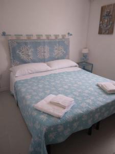 a bedroom with a bed with two towels on it at La Dea Madre in Stintino