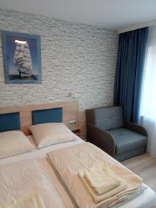 um quarto com uma cama e uma cadeira em Villa Selavi em Kolobrzeg