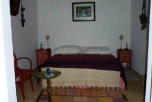 a bedroom with a bed and two chairs and a table at Riad Dar Latifa in Essaouira