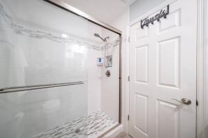a white shower with a glass door in a bathroom at Beach house w/Putting Green/Game Rm/Rooftop Deck in Cocoa Beach