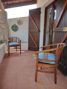 a room with two chairs and a door at La Dea Madre in Stintino
