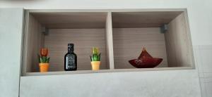 a shelf with a bottle of wine and some vases at At home on the coast in Torre Santa Sabina