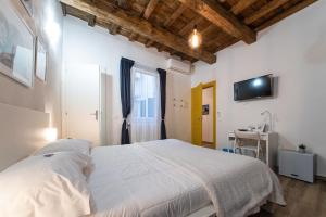 - une chambre avec un lit blanc et un bureau dans l'établissement Florence David's Guesthouse, à Florence