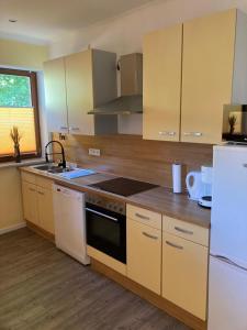 a kitchen with a stove and a white refrigerator at Bergs Bahnhof in Ralingen +22 photos