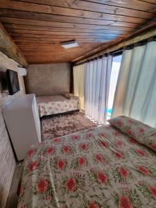 a bedroom with two beds and a television in a room at Casa da Piscina Camboriú in Camboriú