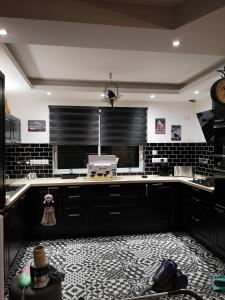 a kitchen with black and white tiles and a counter at La maison du bonheur in Port-en-Bessin-Huppain
