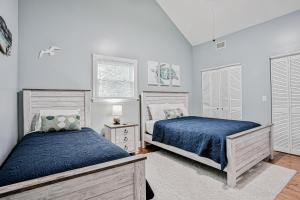 Classic Victorian home near downtown with a private pool, WiFi, & washer/dryer في سانت أوغيستين: سريرين في غرفة نوم بجدران بيضاء +32 صورة