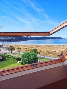 a view of the beach from a window at Omega 1 in Viveiro