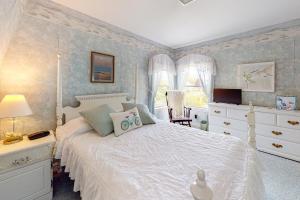 een slaapkamer met een wit bed en blauwe muren bij Elegant Countryside Beach Hideaway in Rye