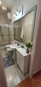 een badkamer met een wastafel, een toilet en een spiegel bij Chic 'N Charme Trastevere Terrace 2 in Rome +33 foto's