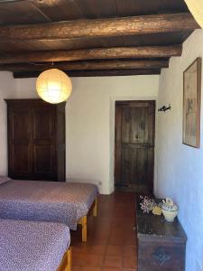 マサネット・デ・カブリニスにあるCasa Rural Can Pipaのベッド2台、テーブル(ランプ付)が備わる客室です。