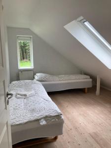 a bedroom with two beds and a stair case at Bøllingsø Feriehus in Silkeborg