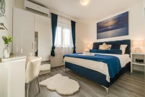 a bedroom with a blue bed and a bath tub at Oliva Vallis Apartments in Zadar