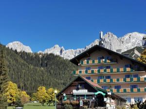 un hotel con una montaña en el fondo en Family Appartment - Dachstein View, en Ramsau am Dachstein
