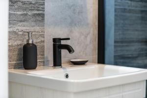 a bathroom sink with a soap dispenser on it at Oliva Vallis Apartments in Zadar