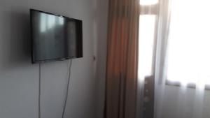 TV de pantalla plana colgada en una pared junto a una ventana en Margo, en Sozopol