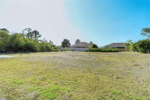 a large grass field with a house in the background at Melody 3-Bedroom Pool Villa close to the beach!!! in Port Charlotte
