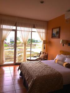 ein Hotelzimmer mit einem Bett und einem großen Fenster in der Unterkunft Park Hotel in Puerto Limón