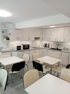 uma cozinha com mesas e cadeiras num quarto em Villa Selavi em Colberga