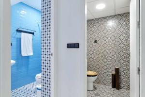 La salle de bains bleue est pourvue de toilettes et d'une douche. dans l'établissement Alojamiento Simon 1 Murcia, à Murcie