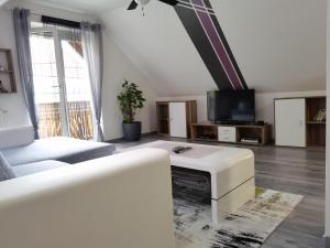 a living room with a white couch and a tv at Ferienwohnung Eckberger Weinstrasse 139 in Gamlitz