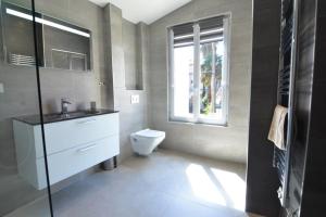 La salle de bains est pourvue de toilettes, d'un lavabo et d'une fenêtre. dans l'établissement T2 Les Altéas - Cozy & Modern apartment - quiet area - city center, à Biarritz