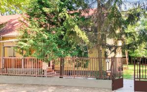 einen Zaun vor einem Haus mit einem Baum in der Unterkunft Sa-Lak Balatonszemes in Balatonszemes