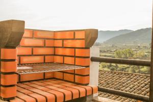 een balkon met een oranje bakstenen muur en uitzicht bij CALA VELLA Casa Vacacional RURAL in Bocairent