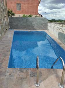 a swimming pool with blue water on a patio at Casa Rural La Vizana in Alija del Infantado