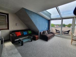 ein Wohnzimmer mit einem Sofa und einem Stuhl in der Unterkunft Apartament Blue Sky in Władysławowo