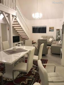 un soggiorno bianco con tavolo e sedie di Maison moderne 8 personnes, jardin, parkings, fibre THD, plage 5 min a Vannes