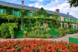 a building covered in ivy with flowers in front of it at Maison Fleurs de Lys, climatisée, WiFi et Parking Privée Gratuit, Lave-Linge, Vernon Giverny in Vernon