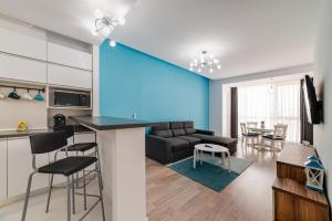 d'une cuisine et d'un salon avec un mur bleu. dans l'établissement Bliss M&M by Onix Blue, à Mamaia Nord – Năvodari