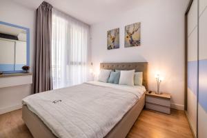 - une chambre avec un grand lit et une fenêtre dans l'établissement Bliss M&M by Onix Blue, à Mamaia Nord – Năvodari