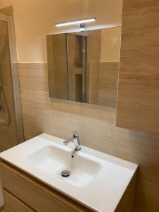 a bathroom with a white sink and a mirror at Marianna's Holidays in Montepaone