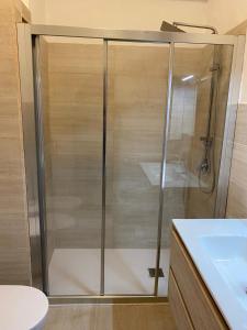 La salle de bains est pourvue d'une douche avec une porte en verre. dans l'établissement Marianna's Holidays, à Montepaone