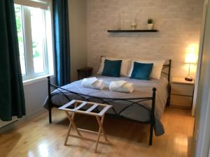 a bedroom with a bed with blue pillows and a table at Les saisons du fleuve in Lotbinière