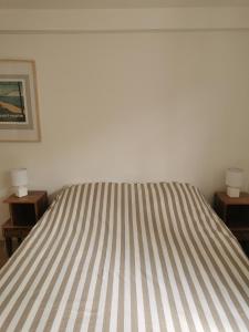 ein Bett in einem Schlafzimmer mit zwei Nachttischen und zwei Lampen in der Unterkunft Les Dunes in Bréhal